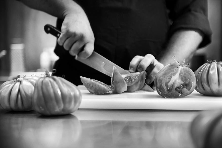 chef de cocina preparando catering de actual catering cortando unos tomates